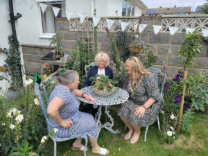 Mayor Lucy chatting at a garden table with local residents taking part in Peacehaven's open garden event